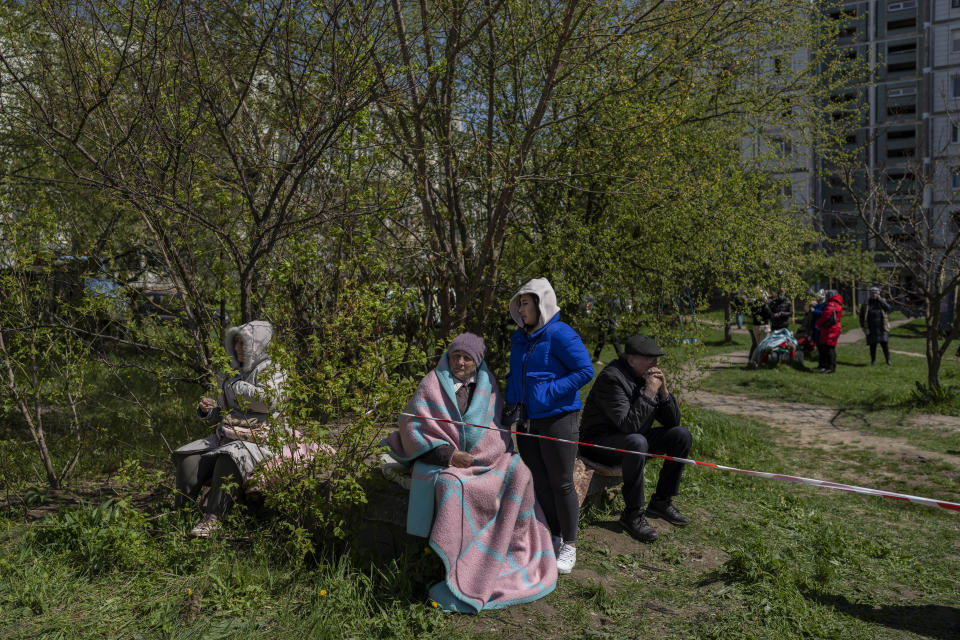 Residents sit outside a residential building that was hit during a Russian attack in Uman, central Ukraine, Friday, April 28, 2023. (AP Photo/Bernat Armangue)