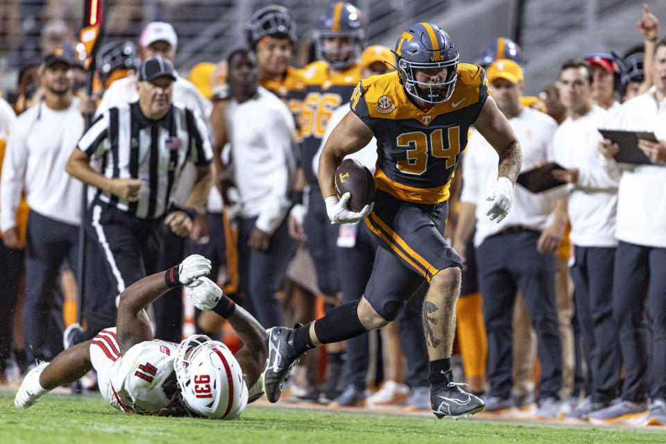 Tennessee tight end McCallan Castles (34) escapes from Austin Peay defensive lineman Darius Richmond (41) and runs for a touchdown during the second half of an NCAA college football game Saturday, Sept. 9, 2023, in Knoxville, Tenn. (AP Photo/Wade Payne)