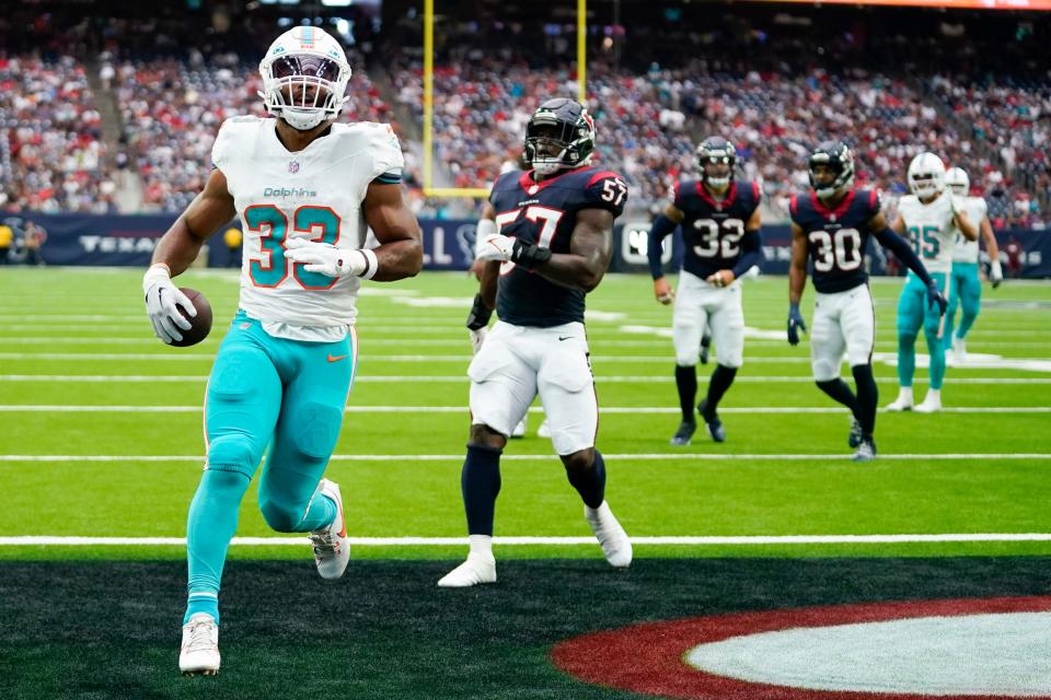 Miami Dolphins running back Chris Brooks (33) reacts after scoring on a touchdown catch in front of Houston Texans linebacker Neville Hewitt (57), linebacker Garret Wallow (32) and cornerback Ka'dar Hollman (30) during the second half of an NFL preseason football game, Saturday, Aug. 19, 2023, in Houston. (AP Photo/Eric Christian Smith)