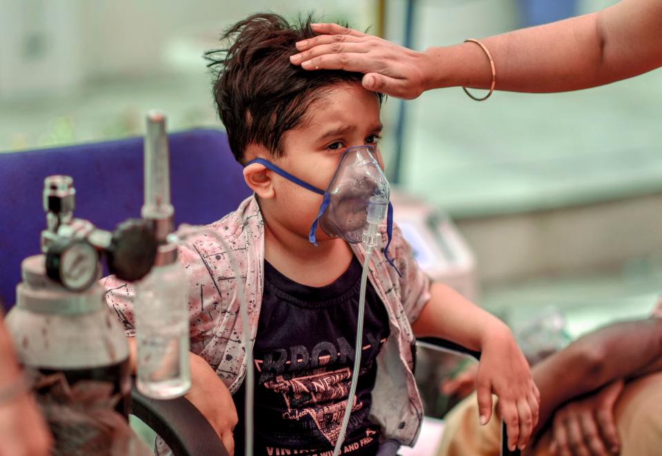 A COVID-19 positive child receives free oxygen provided by a Sikh organization at Indirapuram, Ghaziabad, on Wednesday.