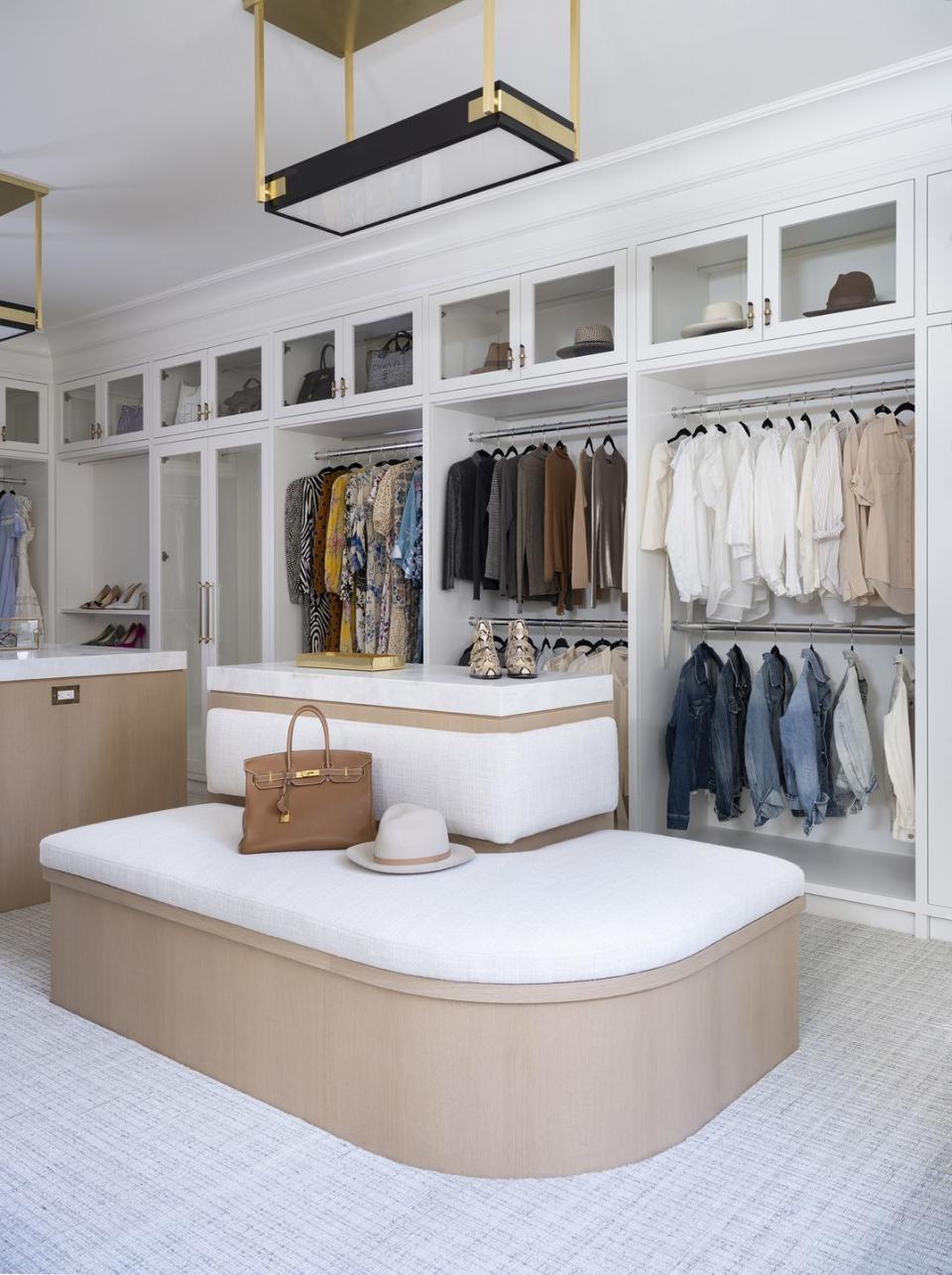 walk in closet with large white seating area