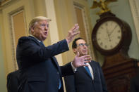 FILE - In this March 10, 2020 file photo, Treasury Secretary Steven Mnuchin listens as President Donald Trump talks to reporters about coronavirus after meeting with Republican lawmakers on Capitol Hill in Washington. Trump has been telling voters that the U.S. economy will leap back to life “like a rocket,” stronger than ever after its bout with the coronavirus. But there is a reason economics is called the “dismal science.” There are emerging signs that any recovery will fail to match the speed and severity of the economic collapse that occurred in just a few weeks. (AP Photo/Evan Vucci)