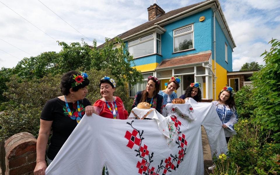 Kristina Korniiuk, 34, (third left) who is originally from Kyiv and fled the Ukraine following the Russian invasion, marks the Ukrainian celebration of Vyshyvanka Day with a giant traditional shirt, near the home of her host Rend Platings (second right) in Cambridge. Kristina was joined by fellow Ukranian's Anastasiia Romaniuk (second left) and sisters Alla Madich (left) and Iryna Madich (third right).  - Joe Giddens/PA