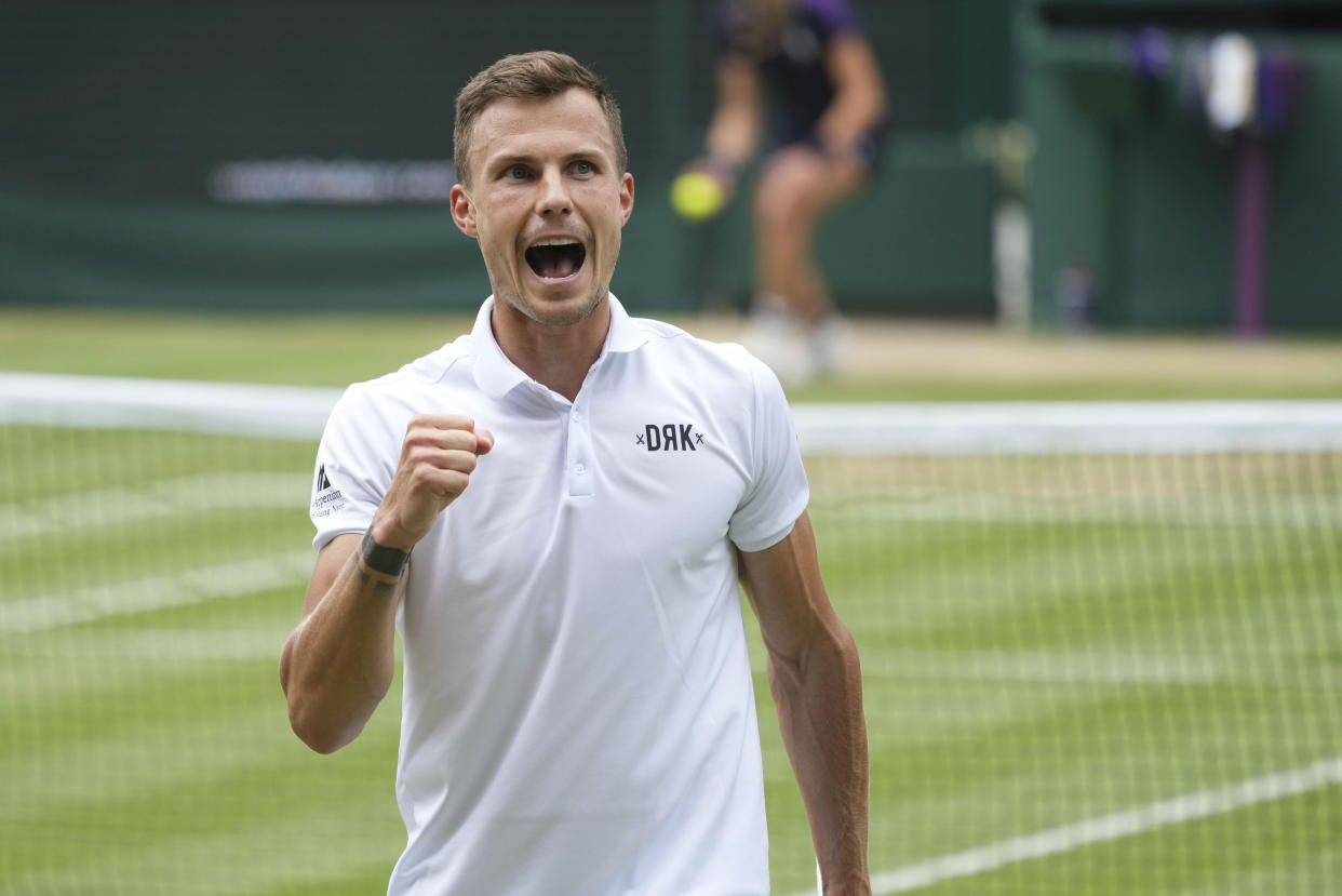 Hungary's Marton Fucsovics celebrates winning a point against Serbia's Novak Djokovic during the men's singles quarterfinals match on day nine of the Wimbledon Tennis Championships in London, Wednesday, July 7, 2021. (AP Photo/Alberto Pezzali)