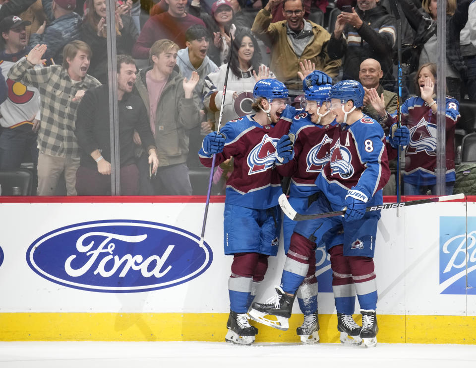 From left, Colorado Avalanche defenseman Bowen Byram, center Nathan MacKinnon and defenseman Cale Makar celebrate after MacKinnon scored the go-ahead goal against the Calgary Flames in the third period of an NHL hockey game Monday, Dec. 11, 2023, in Denver. (AP Photo/David Zalubowski)