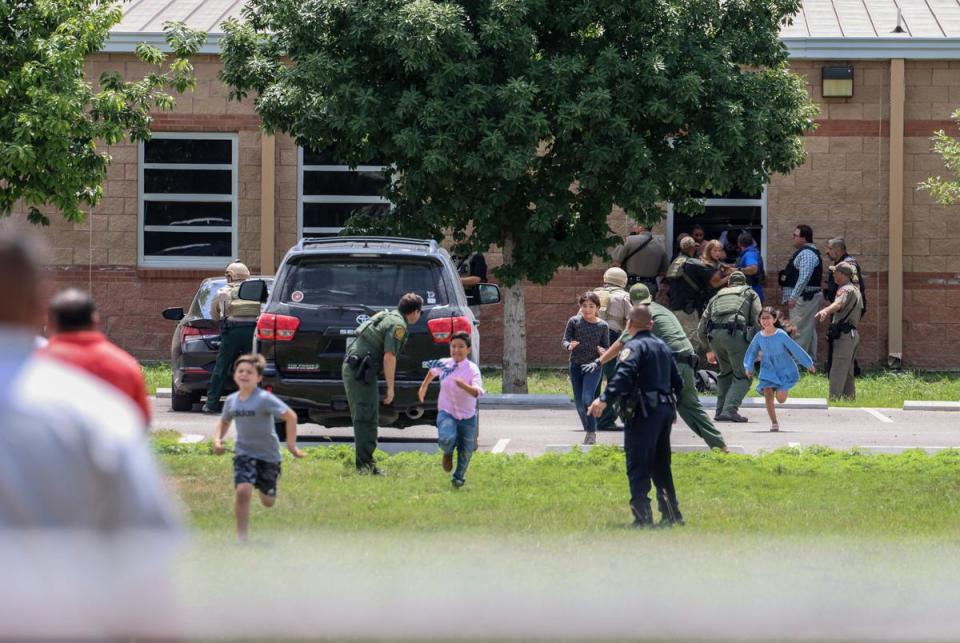 Students flee and authorities help others evacuate after a gunman entered Robb Elementary School in Uvalde on May 24, 2022.