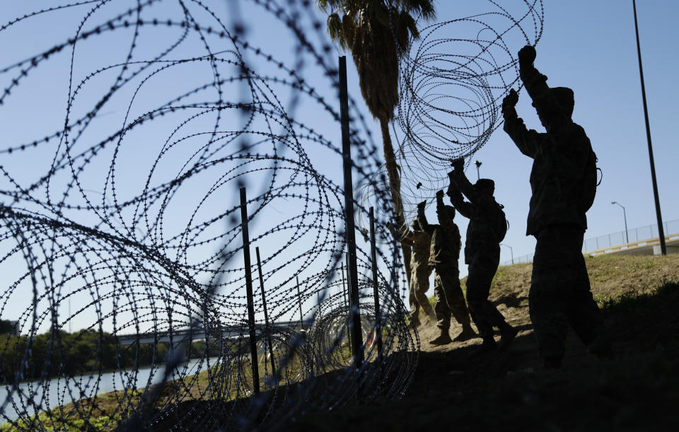 FILE - Members of the U.S. military install multiple tiers of concertina wire along the banks of the Rio Grande near the Juarez-Lincoln Bridge at the U.S.-Mexico border, in Laredo, Texas, Nov. 16, 2018. (AP Photo/Eric Gay, File)
