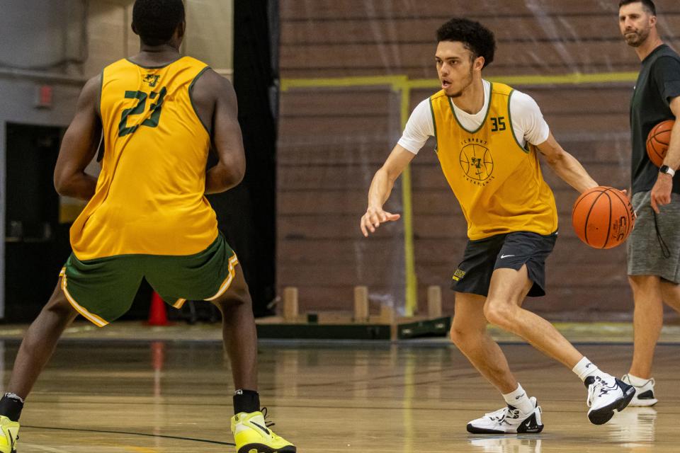 Transfer Jace Roquemore surveys the court next to freshman Noah Barnett, left, during a UVM men's basketball summer practice earlier this month at Patrick Gym.