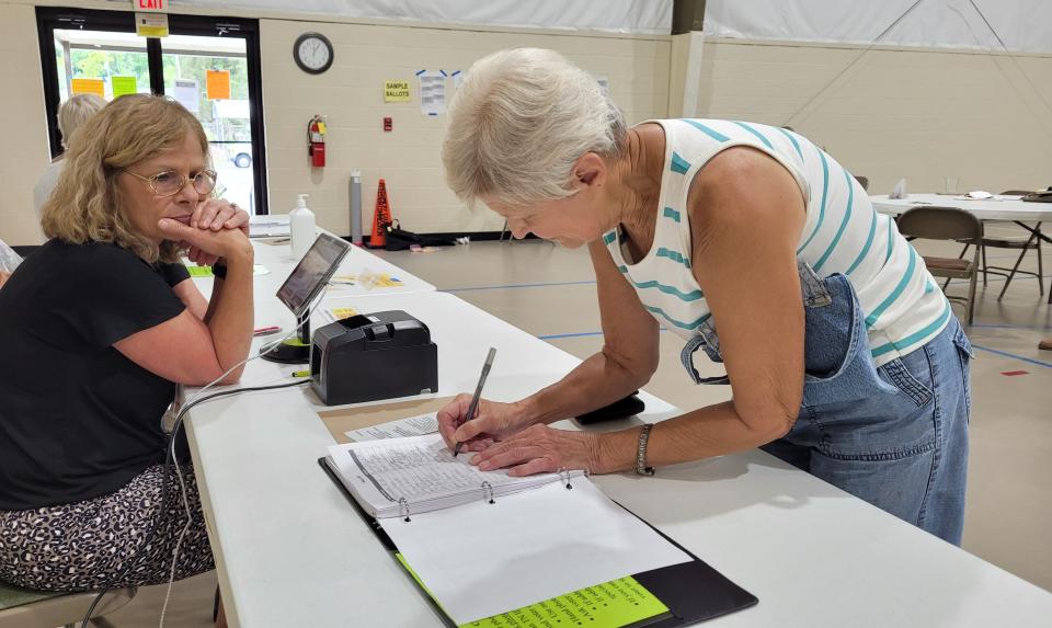 Cindy O'Bryan helps Patsy Ketch get checked in and ready to vote on Thursday, Aug. 4, 2022.