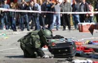 A bomb disposal expert inspects a suitcase at the site of twin explosions near the main train station in Ankara, on October 10, 2015