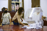 Turkish Cypriots election staff members empty a ballot box at a polling station in the Turkish occupied area in the north part of the divided capital Nicosia, Cyprus, Sunday, Oct. 18, 2020. Turkish Cypriots vote to choose a leader who'll explore, with rival Greek Cypriots, whether there's enough common ground left for a deal to end the island's decades of ethnic division. (AP Photo/Nedim Enginsoy)
