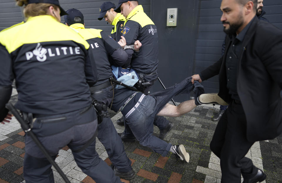 A demonstrator is detained by police officers as French President Emmanuel Macron and Dutch King Willem-Alexander arrive at the science faculty of the UvA, University of Amsterdam, Netherlands, Wednesday, April 12, 2023. Macron's two-day trip to Amsterdam and The Hague is the first state visit by a French leader since Jacques Chirac 23 years ago and underscores the close links between the Netherlands and France and the two leaders. (AP Photo/Peter Dejong)