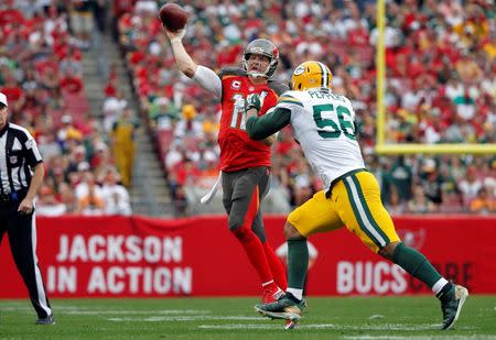 Dec 21, 2014; Tampa, FL, USA; Tampa Bay Buccaneers quarterback Josh McCown (12) throws the ball as Green Bay Packers outside linebacker Julius Peppers (56) pressures during the first half at Raymond James Stadium. Mandatory Credit: Kim Klement-USA TODAY Sports