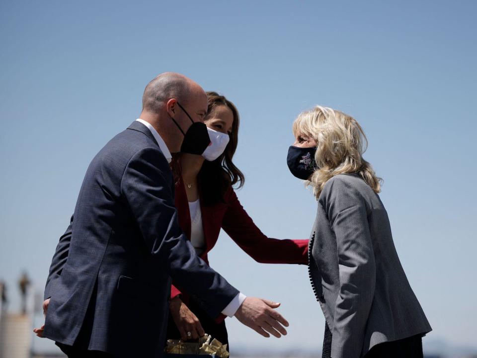 Utah Gov. Spencer Cox and his wife, Abby, gesture to First Lady Jill Biden after she arrives in Salt Lake City.t