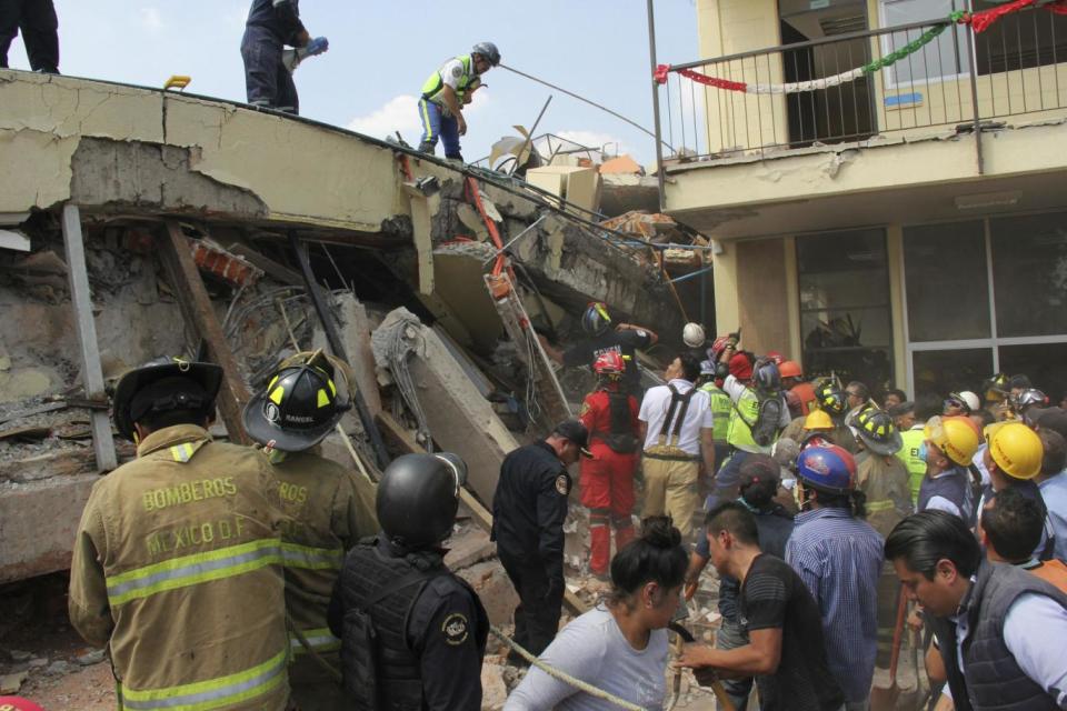 Rescue workers search for children trapped inside the collapsed Enrique Rebsamen school in Mexico City (AP Photo/Carlos Cisneros)