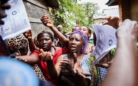 Villagers react as the United Nations Police forces conduct an Ebola awareness campaign - Credit: HUGH KINSELLA CUNNINGHAM/EPA-EFE/REX