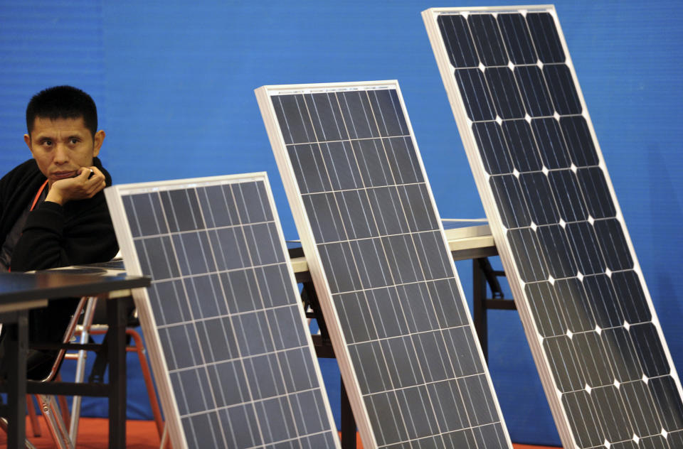 An exhibitor of solar panels waits for potential customers at a fair for photovoltaic products in Nanjing in east China's Jiangsu province Friday Nov. 9, 2012. China's auto sales, consumer spending and factory output improved in October in a new sign of economic recovery as the Communist Party prepared to install a new generation of leaders. Growth in factory output accelerated to 9.6 percent over a year earlier from the previous month's 9.2 percent, the government reported Friday. (AP Photo) CHINA OUT