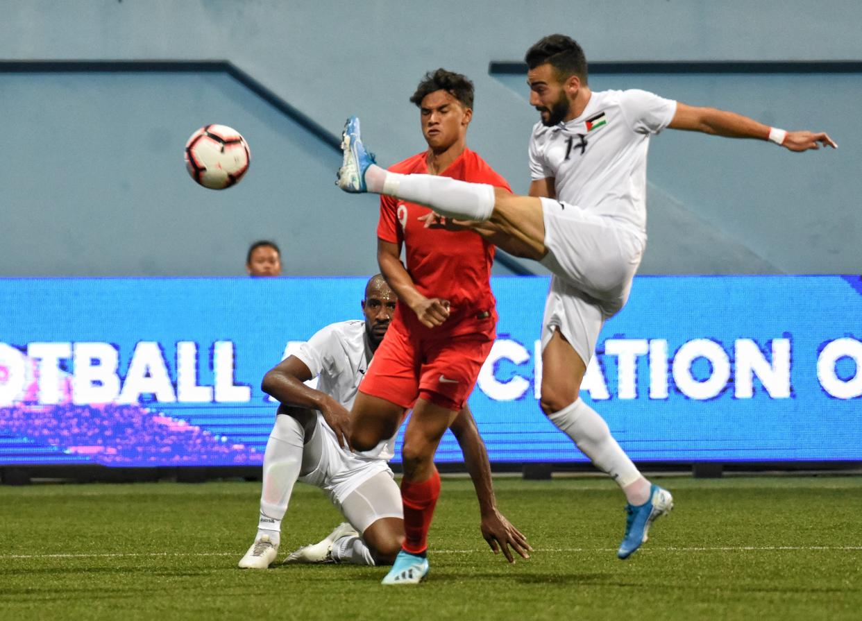 Singapore's Ikhsan Fandi (red jersey) tussles for the ball with Palestine's Abdallah Jaber in their 2022 World Cup qualifier at the Jalan Besar Stadium. (PHOTO: Football Association of Singapore)