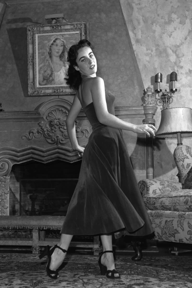 <p>The full skirt and tight bustier of Elizabeth Taylor's dress was the epitome of style in the 1950s, but rather than follow the bright print and pattern trend of the time, the young starlet opted for a simple black fabric. </p>