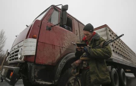 A pro-Russian separatist checks a driver's documents in Zhdanivka town, northeast from Donetsk, February 2, 2015. REUTERS/Maxim Shemetov