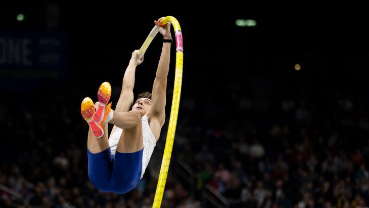 A man with a level pole vault bends into form