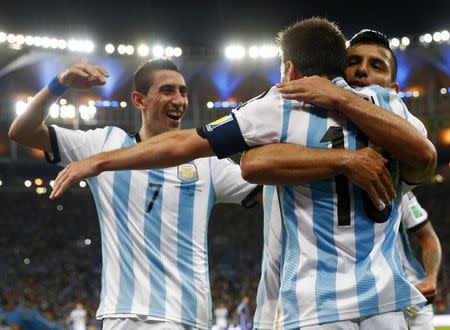 Argentina's Lionel Messi is congratulated by his teammates Sergio Aguero (R) and Angel Di Maria (L) after scoring a goal against Bosnia during their 2014 World Cup Group F soccer match at the Maracana stadium in Rio de Janeiro June 15, 2014. REUTERS/Michael Dalder