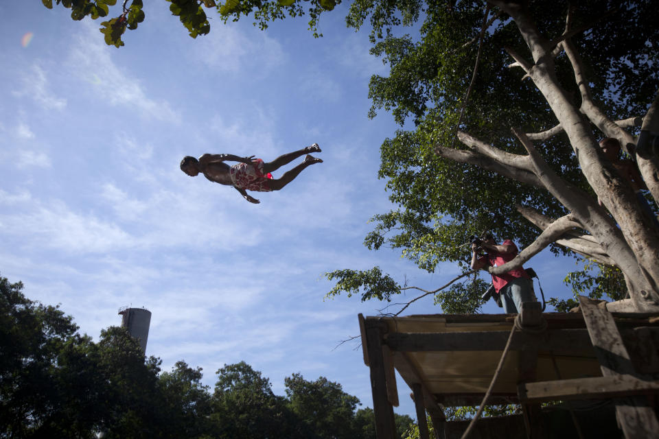A teenager jumps into the Jacare river, one of the most polluted rivers in the country, to show the media how they usually take a swim there at Manguinhos slum in Rio de Janeiro, Brazil, Monday, June 18, 2012. The non-governmental organization "Rio de Paz" or "River of Peace" organized a media tour to Manguinhos slum, one of the most polluted, poor and violent slums, while the city hosts the Rio+20 United Nations Conference on Sustainable Development that runs through June 22. (AP Photo/Victor R. Caivano)