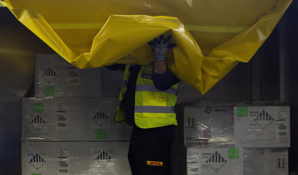 A cargo worker opens a truck of cool boxes as he demonstrates the handling and logistics of vaccines and medicines at the DHL cargo warehouse in Steenokkerzeel, Belgium, Tuesday, Dec. 1, 2020. European Commission President Ursula von der Leyen said Tuesday that member states have started working on their vaccination plans and on the logistics for the delivery of tens of millions of doses across the 27-nation bloc. Safely delivering COVID-19 vaccines, once approval has been made, will be the mission of the century for the global air cargo industry. (AP Photo/Virginia Mayo)