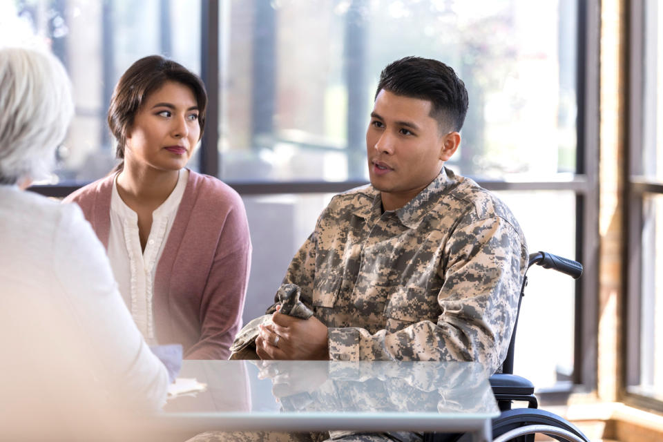 army vet in wheelchair with his wife talking to a counselor