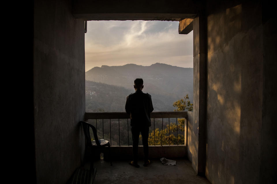 A police officer who fled from Myanmar following a military coup looks out to the mountains from an undisclosed location bordering Myanmar, in the northeastern Indian state of Mizoram, Thursday, March 18, 2021. Villagers in Mizoram have given shelter to 34 Myanmar police personnel and 1 fire fighter, who crossed over to the state over the last two weeks. They refused to give their names to an Associated Press photographer who met them this week in an undisclosed location in Mizoram state. (AP Photo/Anupam Nath)