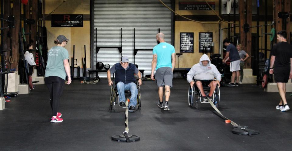 Participants pull weights during the spinal cord injury class at CrossFit Fort Smith May 26.