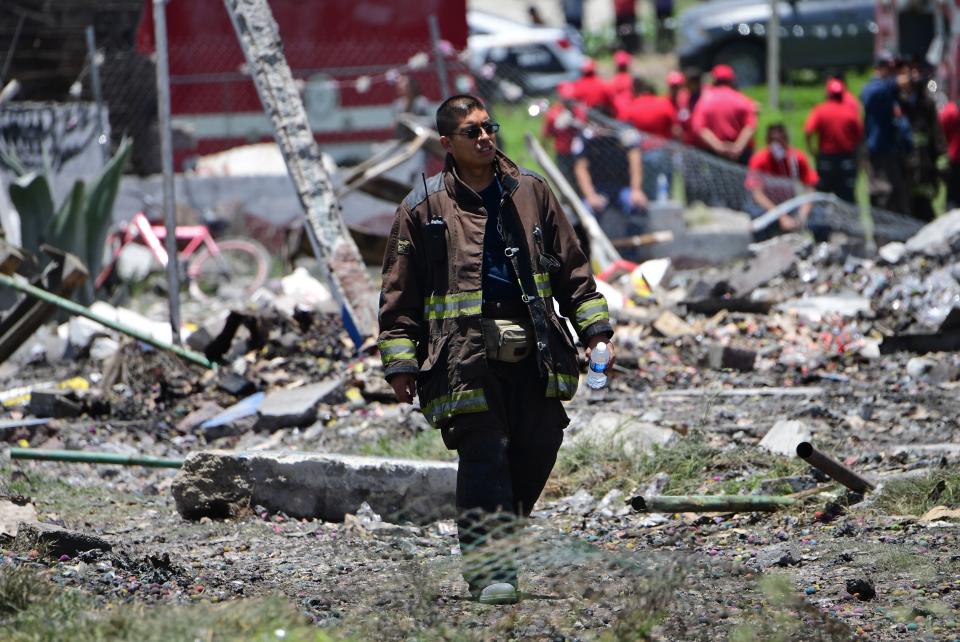 <p>A firefighter walks at the site of a series of explosions at fireworks warehouses in Tultepec, central Mexico, on July 5, 2018. – At least 19 people were killed, including rescue workers who died saving others’ lives, officials said. The initial explosion occurred around 9:30 am (1430 GMT), then spread to other warehouses just as police and firefighters began attending to the first victims. (Photo: Pedro Pardo/AFP/Getty Images) </p>