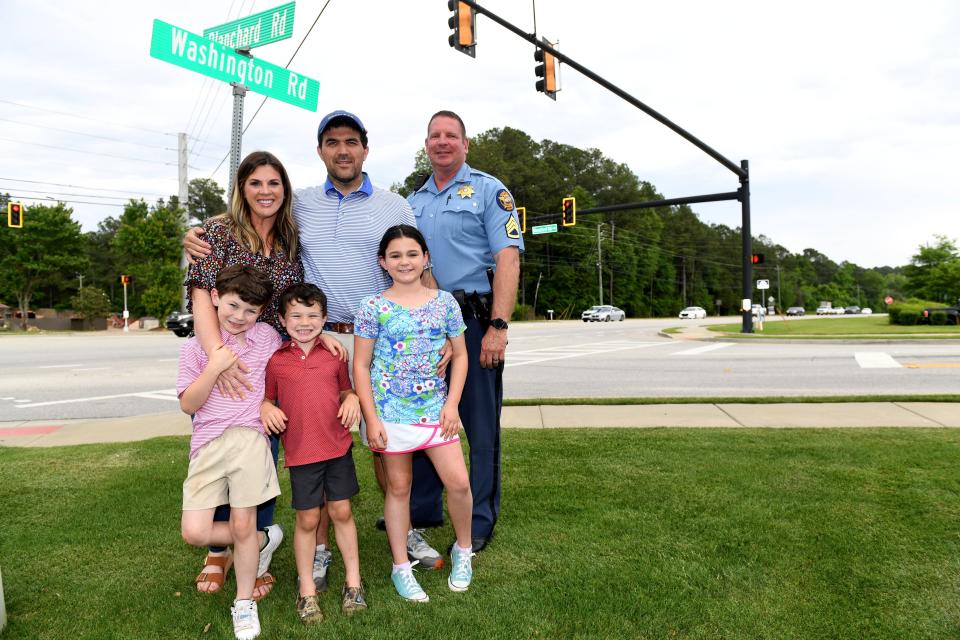 Deputy Tim Johnson (right) poses for a portrait with Will Johnson (center), wife Morgan Johnson, and kids Carter (left), Collin (center), and Charley (right) at the intersection of Washington Road and Blanchard Road on Tuesday, April 30, 2024.