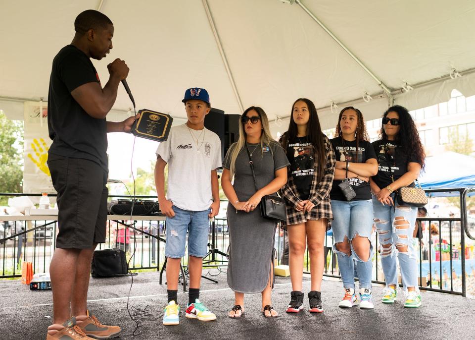 The family of fallen Worcester Police Officer Manny Familia are honored by Woodrow Adams, Jr. with the inaugural Adams Family Strong award at the 508 Forever Young event Aug. 28, 2021.