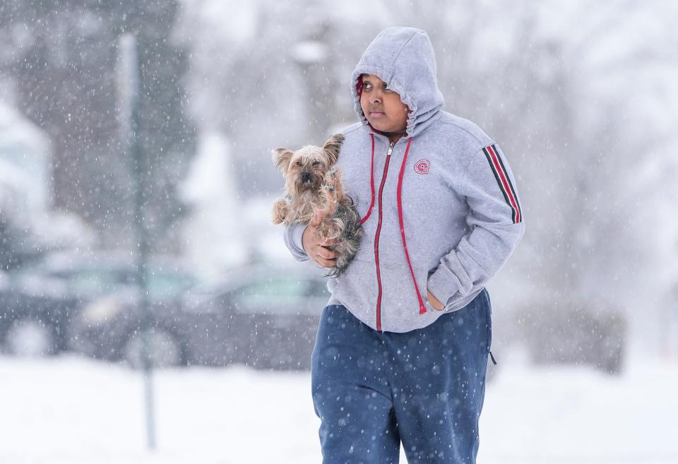 When she started shivering and her tiny paws got too cold to take the snow, Malachi Herring, 14, carries his 3-year-old Yorkie, Stormy, back to his house as snow continues to fall in South Linden on Monday, Jan. 24, 2022. Frigid temperatures and light snowfall are expected throughout the rest of the week.
