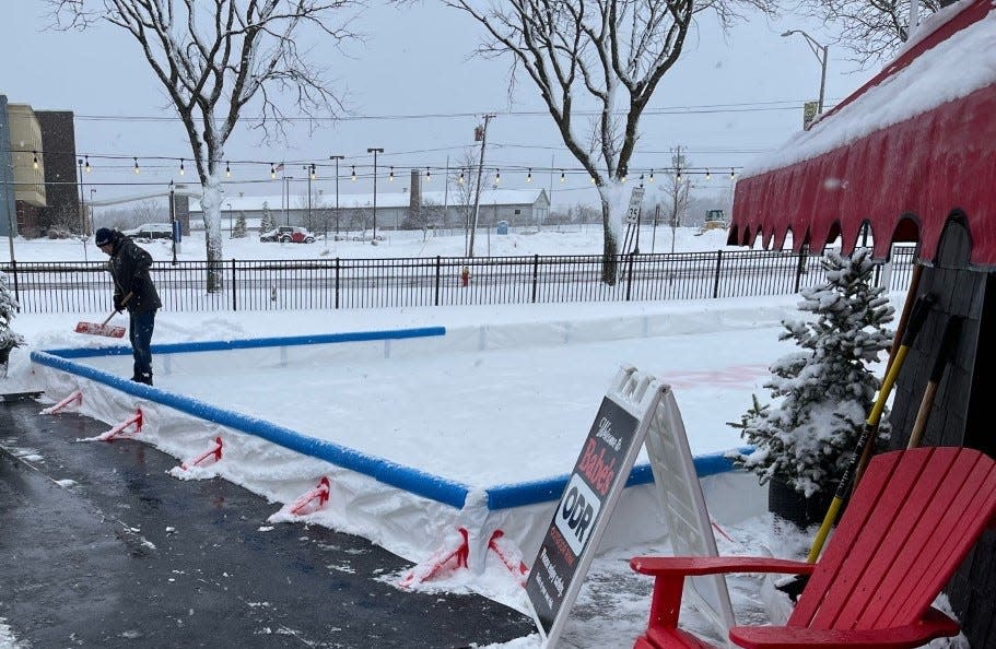 A worker tends to the new ice-skating rink set up outside of Babe's on North Genesee Street in Utica.