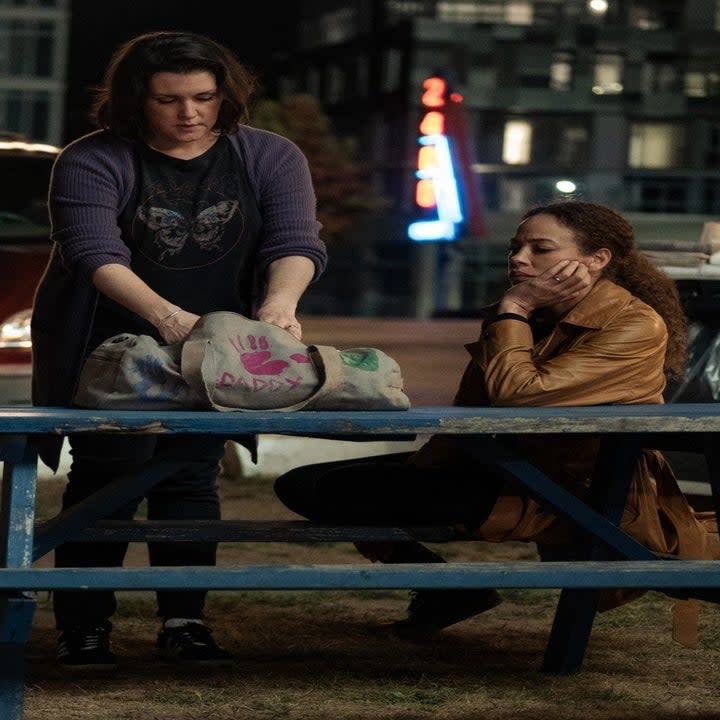 the characters on the show sitting on a picnic bench