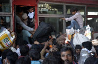 GHAZIABAD, INDIA - MARCH 28: Migrant workers try to board an overcrowded bus bound to their native state on Day 4 of the 21 day nationwide lockdown -- to check the spread of coronavirus, at Lal Kuan bus stand, on March 28, 2020 in Ghaziabad, India. (Photo by Sakib Ali/Hindustan Times via Getty Images)