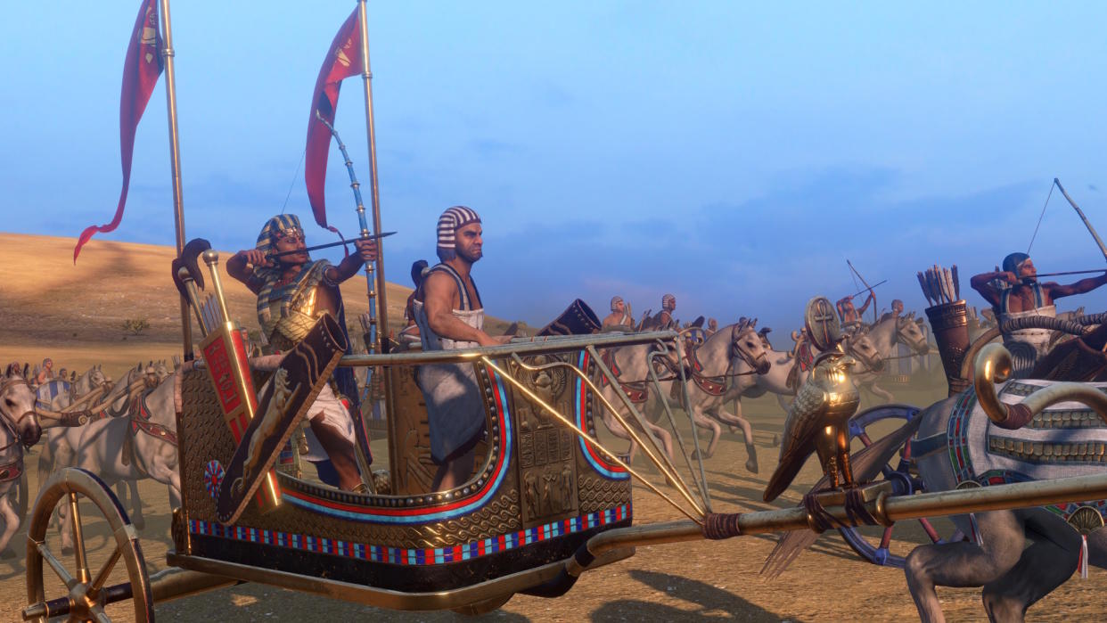  Total War: Pharaoh screenshot shows a faction leader in a chariot surrounded by ally forces 