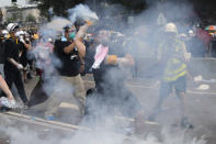 A demonstrator throws a canister of tear gas back towards the police outside the Legislative Council in Hong Kong, Wednesday, June 12, 2019. Hong Kong police fired tear gas and high-pressure water hoses against protesters who had massed outside government headquarters Wednesday in opposition to a proposed extradition bill that has become a lightning rod for concerns over greater Chinese control and erosion of civil liberties in the semiautonomous territory. (AP Photo/Kin Cheung)