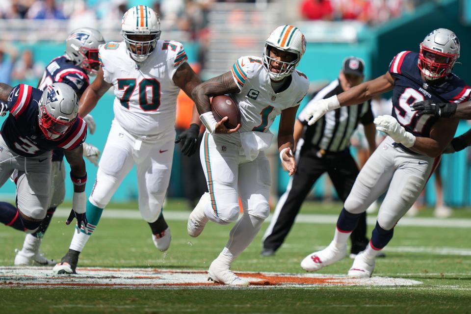 Miami Dolphins quarterback Tua Tagovailoa (1) breaks free for a first down against the New England Patriots during the first half of an NFL game at Hard Rock Stadium in Miami Gardens, Oct. 29, 2023.