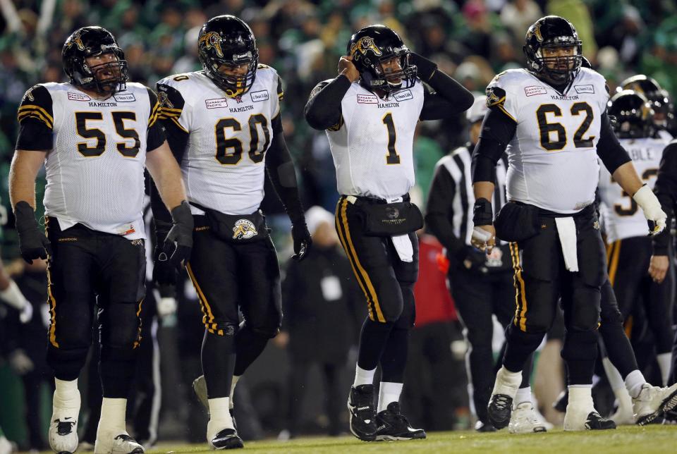 Hamilton Tiger-Cats quarterback Henry Burris (1) walks off the field with teammates Tim O'Neill (55), Joel Figueroa (60) and Marwan Hage (62) during the second half of the CFL's 101st Grey Cup championship football game against teh Saskatchewan Roughriders in Regina, Saskatchewan November 24, 2013. REUTERS/Mark Blinch (CANADA - Tags: SPORT FOOTBALL)