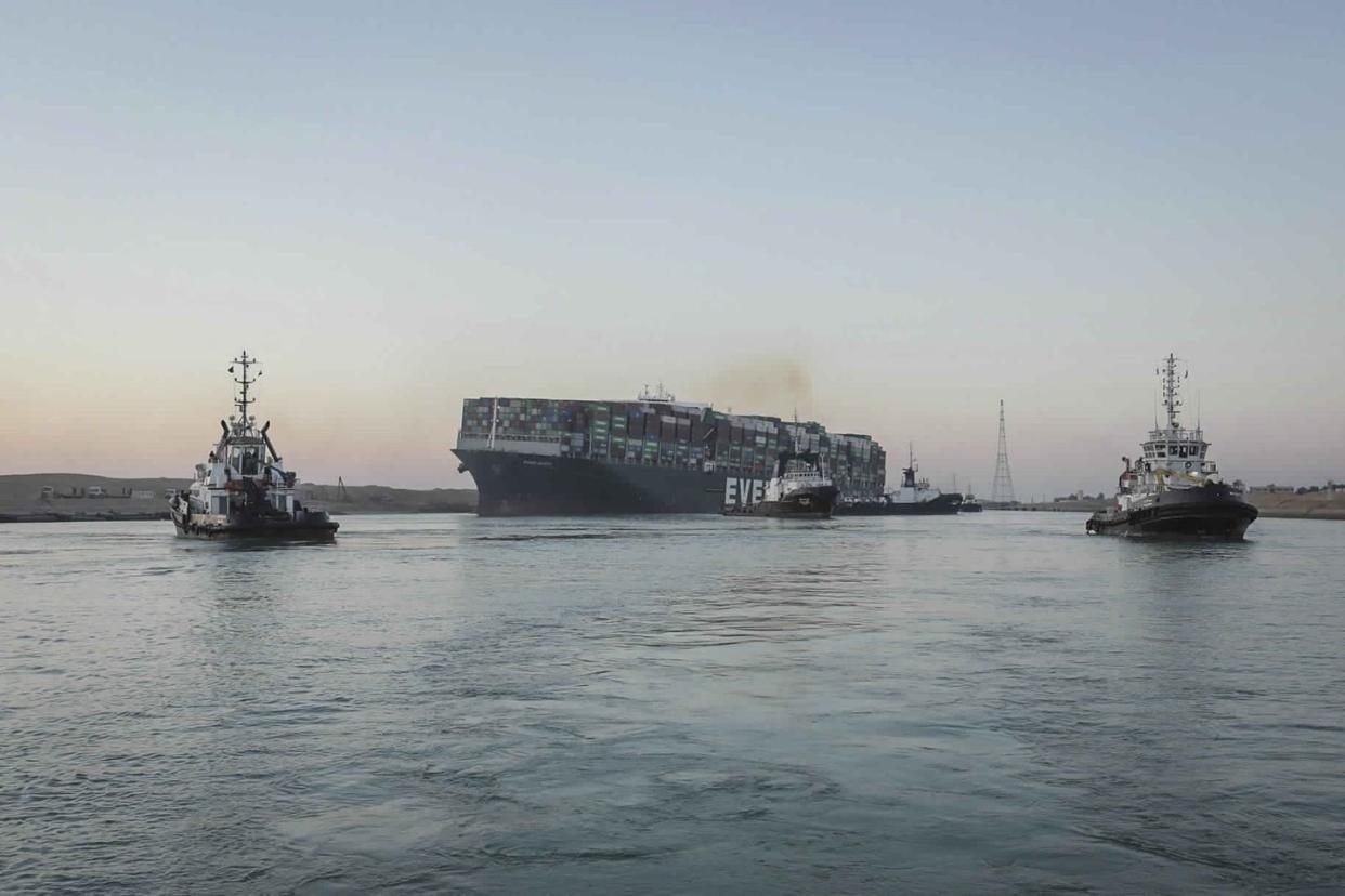 In this photo released by Suez Canal Authority, the Ever Given, a Panama-flagged cargo ship, is pulled by tugboats, in the Suez Canal, Egypt on Monday, March 29, 2021. A canal service provider said Monday that workers have successfully set free the colossal container ship that for nearly a week has been stuck sideways across the Suez Canal, one of the world’s most crucial arteries for trade.