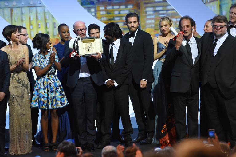 French director Jacques Audiard (C) poses on stage with Feature Film jury members after being awarded with the Palme d'Or for his film "Dheepan" during the closing ceremony of the 68th Cannes Film Festival in Cannes, France, on May 24, 2015