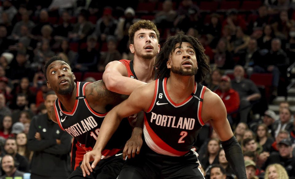 Portland Trail Blazers forward Nassir Little, left, and Trendon Watford, right, battle with Houston Rockets center Alperen Sengun, center, for position under the basket during the first half of an NBA basketball game in Portland, Ore., Sunday, Feb. 26, 2023. (AP Photo/Steve Dykes)