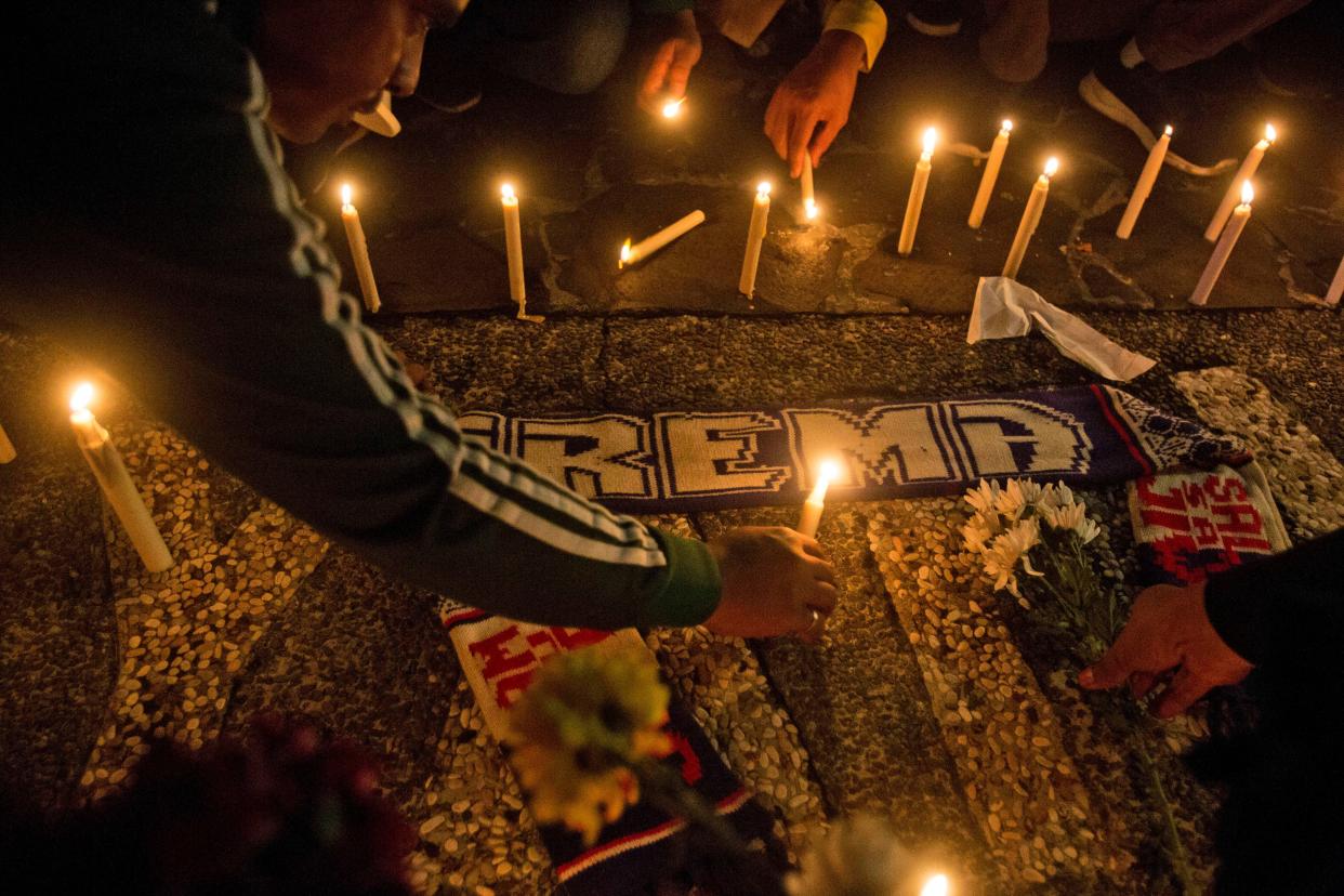 Soccer fans light candles during a vigil for supporters of Arema FC who died in Saturday's stampede, in Medan, North Sumatra, Indonesia, Monday, Oct. 3, 2022. Indonesian police said they were investigating over a dozen officers responsible for firing tear gas that set off a crush that killed a number of people at a soccer match between Arema FC of Malang and Persebaya of neighboring Surabaya city, as families and friends grieved Monday for the victims that included children. (AP Photo/Binsar Bakkara)