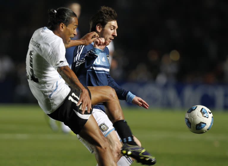 Lionel Messi de Argentina, a la derecha, y Álvaro Pereira de Uruguay luchan por el balón durante un partido de cuartos de final de la Copa América en Santa Fe, Argentina, el sábado 16 de julio de 2011. (Foto AP/Ricardo Mazalan)