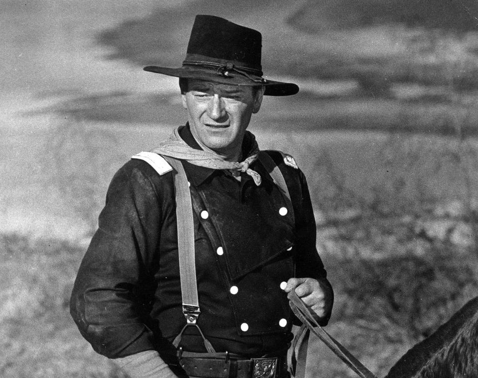 FILE - In this undated photo, John Wayne appears during the filming of "The Horse Soldiers." In the latest move to change place names in light of U.S. racial history, leaders of Orange County’s Democratic Party are pushing to drop film legend Wayne’s name, statue and other likenesses from the county’s airport because of his racist and bigoted comments. (AP Photo, File)