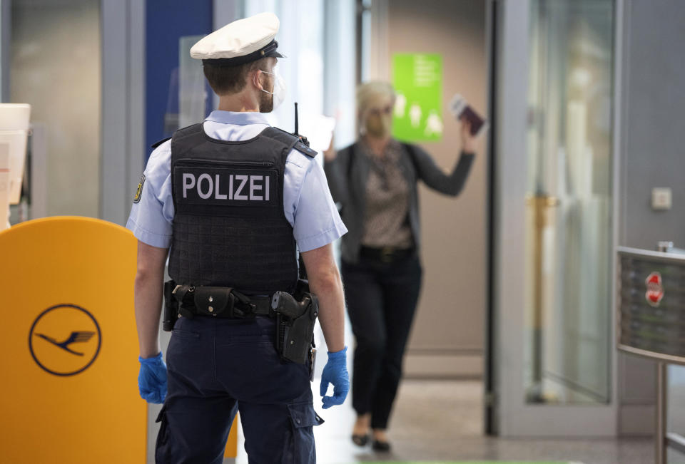 Federal police officers check passengers arriving aboard a flight from Portugal, at Frankfurt airport, Germany, Tuesday June 29, 2021. As of Tuesday, Portugal is being considered a virus variant area, and people arriving in Germany must go into quarantine. (Boris Roessler/dpa via AP)