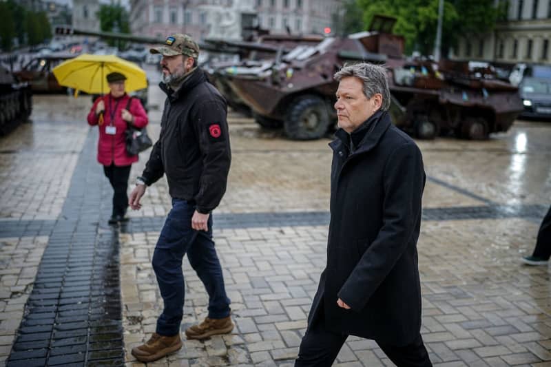 Robert Habeck (R), Germany's Minister for Economic Affairs and Climate Protection, visits the memorial wall for the soldiers who died in the war. Kay Nietfeld/dpa